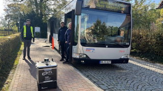 Transportroboter vor Linienbus. Von links nach rechts: Sean Maroofi, Justin Ziegenbein (beide TUHH), Andreas Scheske (VHH)